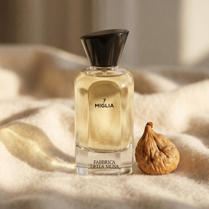 Fabbrica Della Musa Via Velluto EDP on cream cashmere with a single dried fig placed beside the bottle