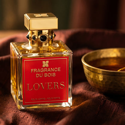 Fragrance du Bois Lovers on burnt-orange raw silk with a brass vial of frankincense oil