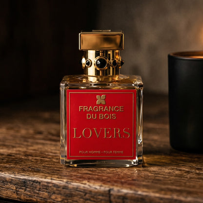 Fragrance du Bois Lovers on dark cherrywood with a tall beeswax taper casting warm light