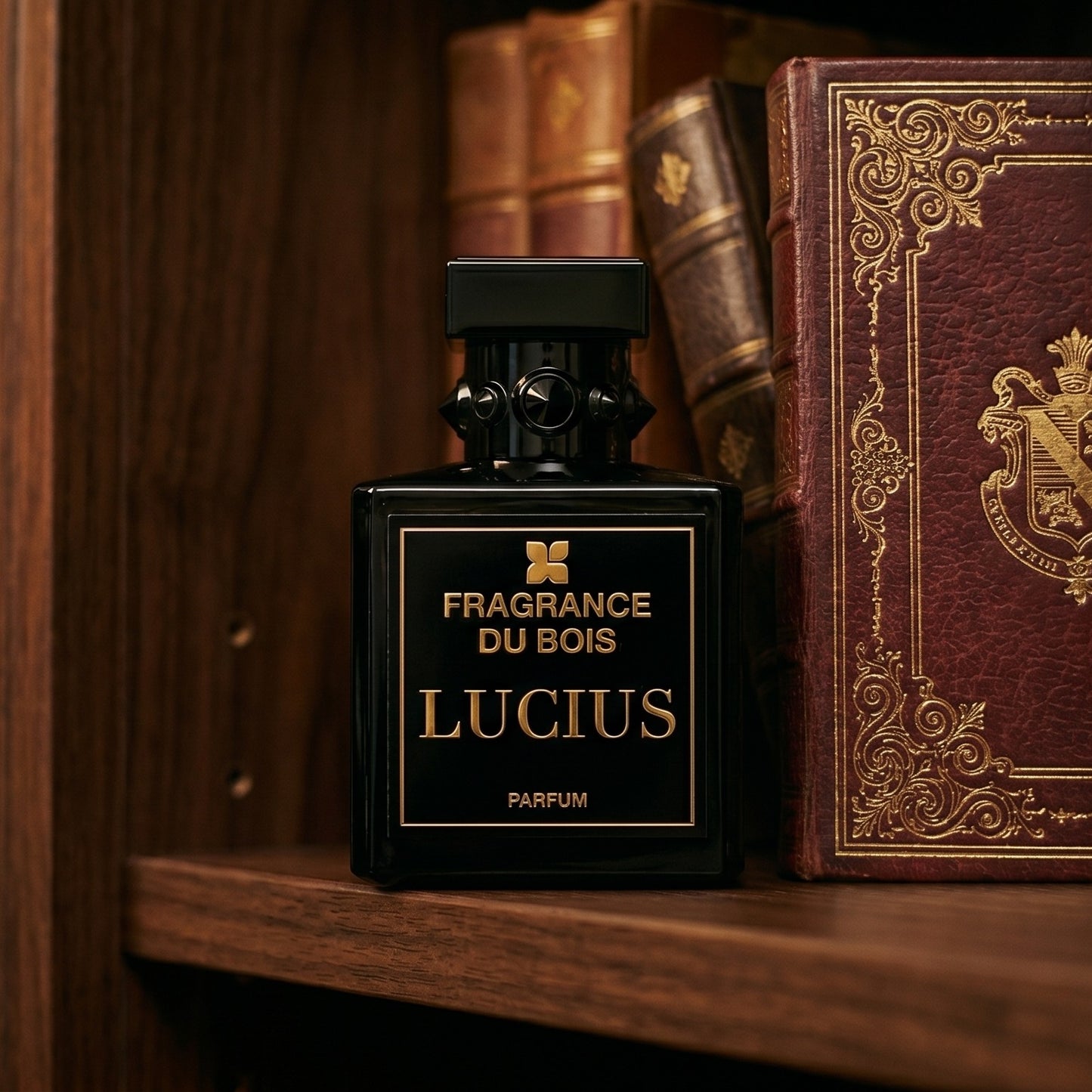 Fragrance du Bois Lucius Parfum on deep burgundy leather journal spread beside a crystal inkwell