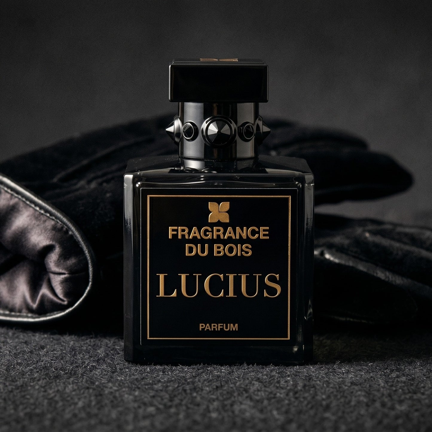 Fragrance du Bois Lucius Parfum on charcoal felt with a silk-lined leather glove placed behind the bottle