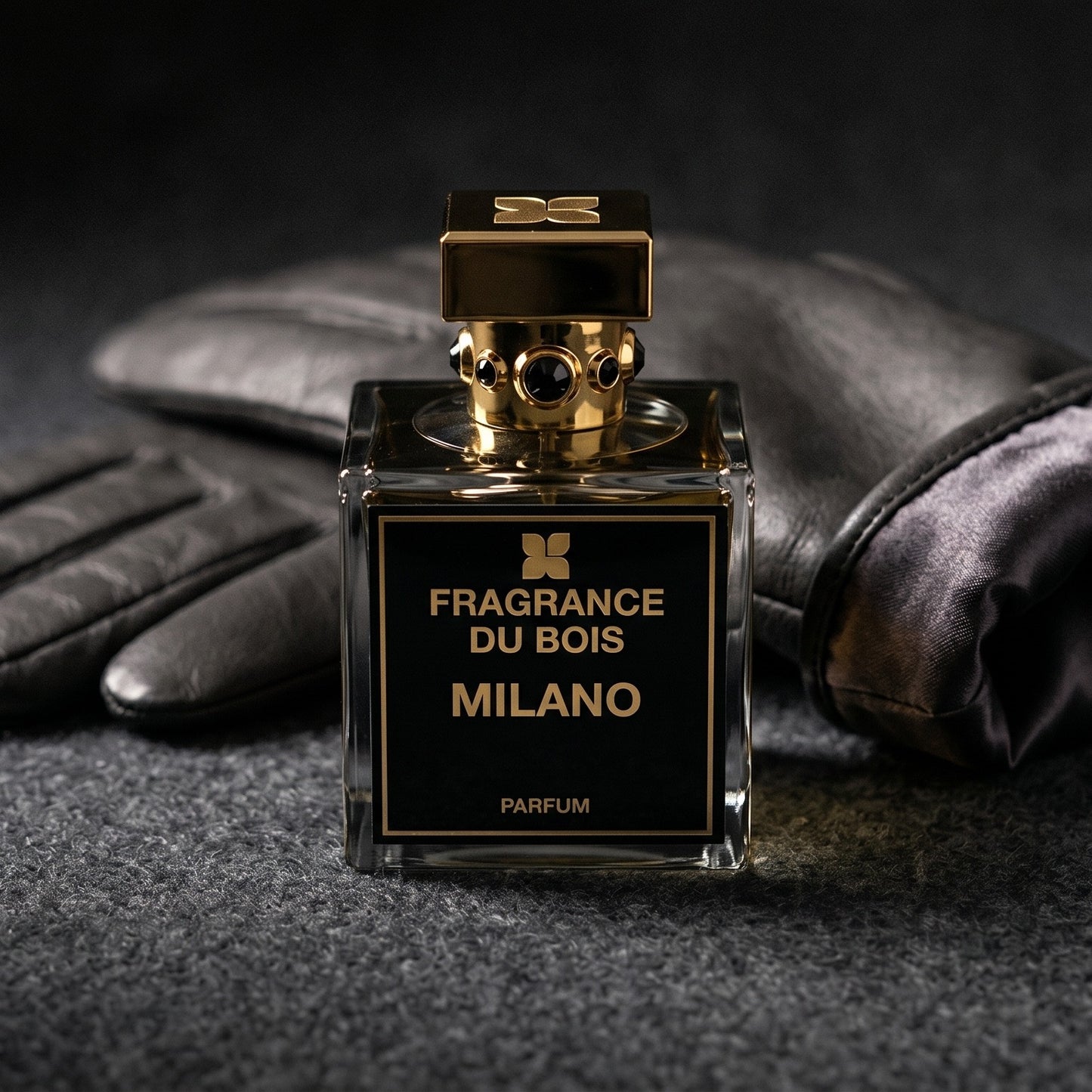 Fragrance du Bois Milano on charcoal felt with a silk-lined leather glove placed behind the bottle