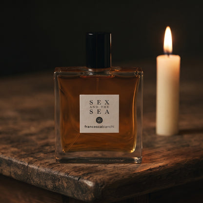 Francesca Bianchi Sex and the Sea EDP on aged teak with a candle burning gently to frame-right