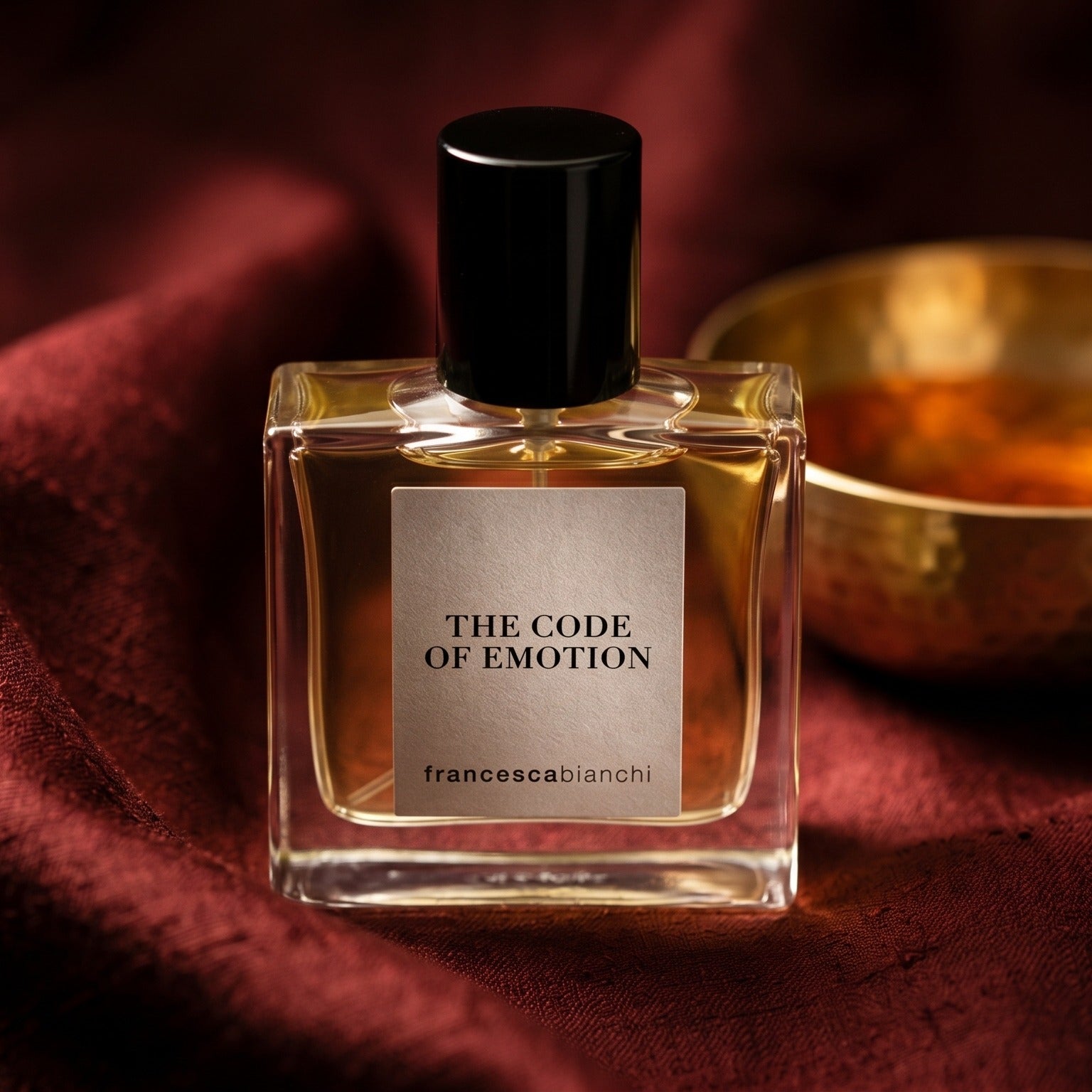 Francesca Bianchi The Code Emotion Extrait de Parfume on burnt-orange raw silk with a brass vial of frankincense oil