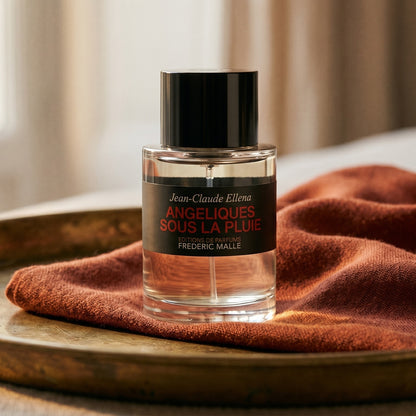 Frederic Malle Angeliques Sous La Pluie EDT on brass-edged surface with a silk-wool wrap in burnt sienna