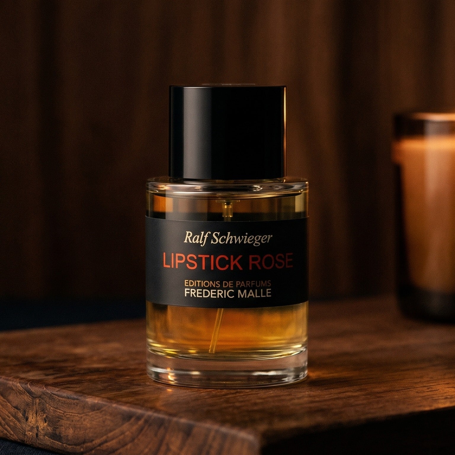 Frederic Malle Lipstick Rose EDP on walnut side table with a pair of lit votives beside the bottle