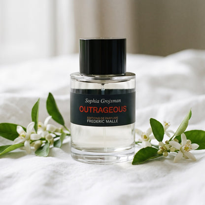 Frederic Malle Outrageous EDT on white linen with sprigs of neroli and orange blossom