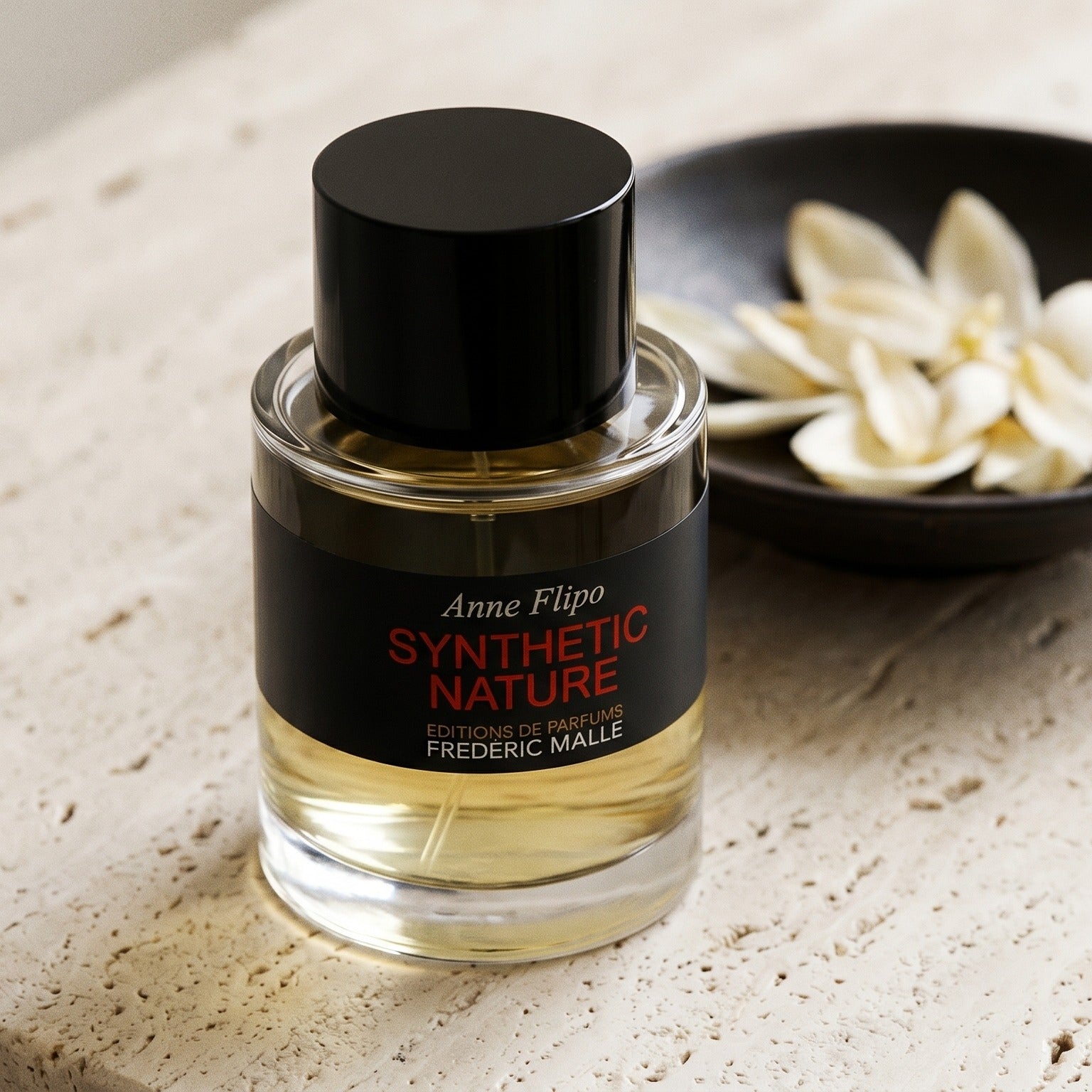 Frederic Malle Synthetic Nature EDP on cream ceramic with ylang-ylang petals drifting from a small dish
