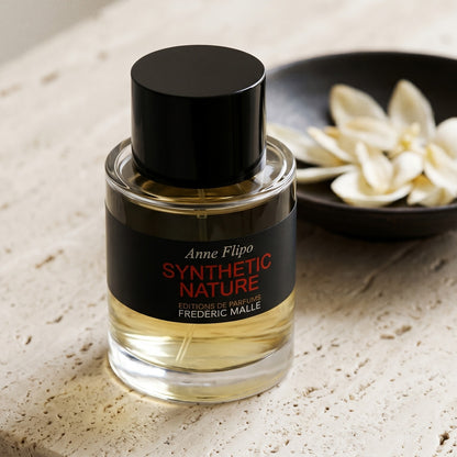 Frederic Malle Synthetic Nature EDP on cream ceramic with ylang-ylang petals drifting from a small dish