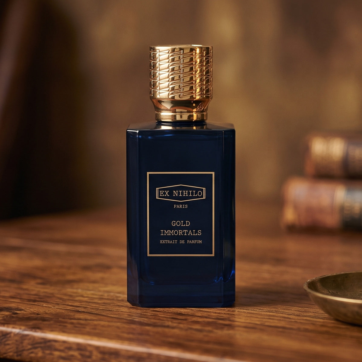 Ex Nihilo Gold Immortals Extrait de Parfum on aged teak with a candle burning gently to frame-right