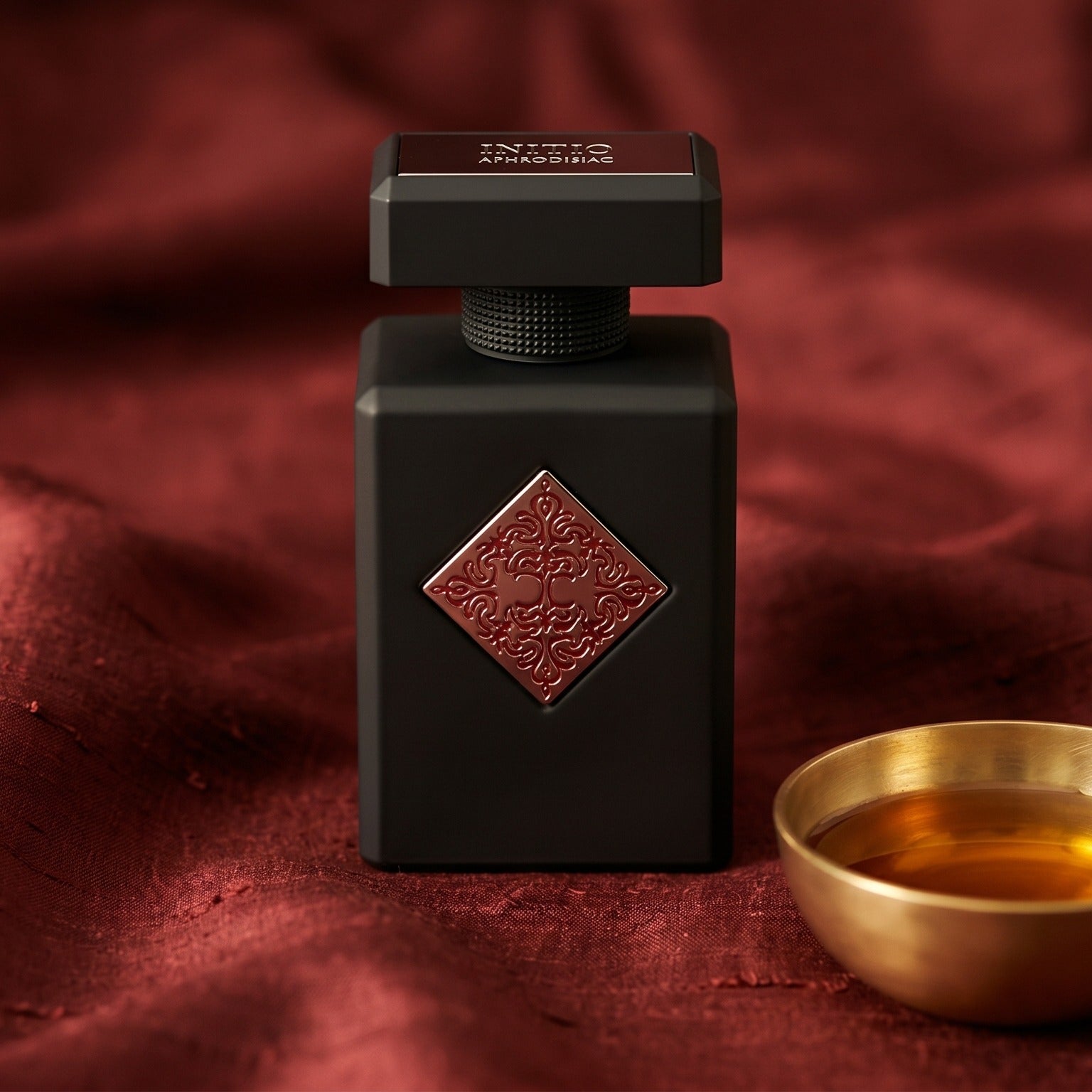 Initio Absolute Aphrodisiac EDP on cinnamon-tone silk with a shallow saucer of warm benzoin resin