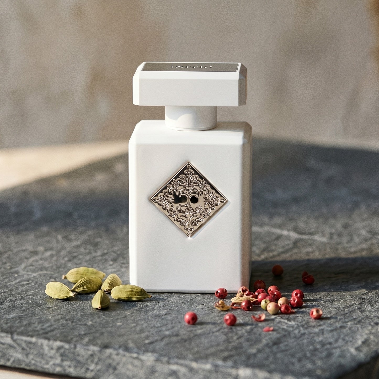 Initio Power Self Extrait de Perfum on deep grey travertine with a scatter of nutmeg and allspice