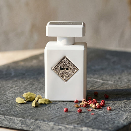 Initio Power Self Extrait de Perfum on deep grey travertine with a scatter of nutmeg and allspice