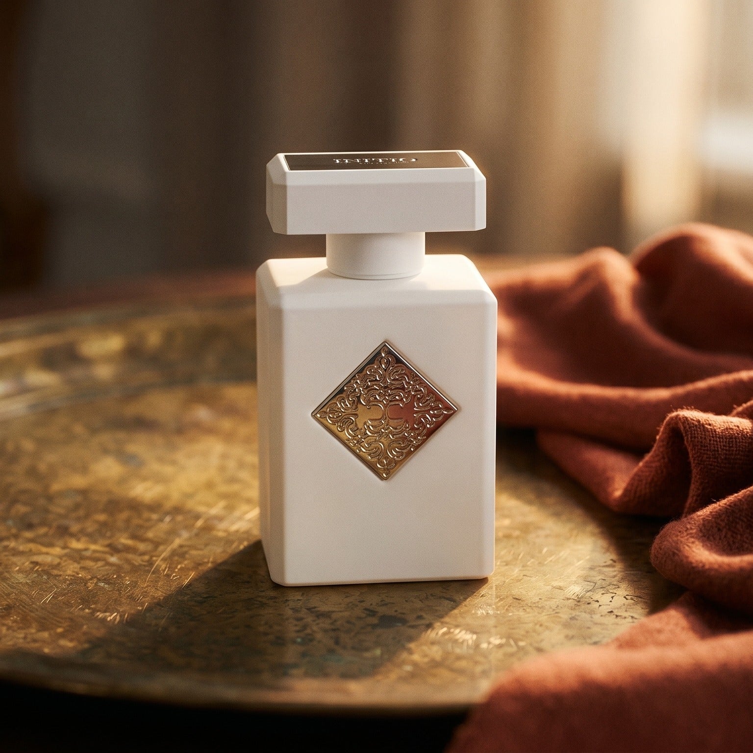 Initio Power Self Extrait de Perfum on weathered brass plate with a wool scarf dyed in paprika red