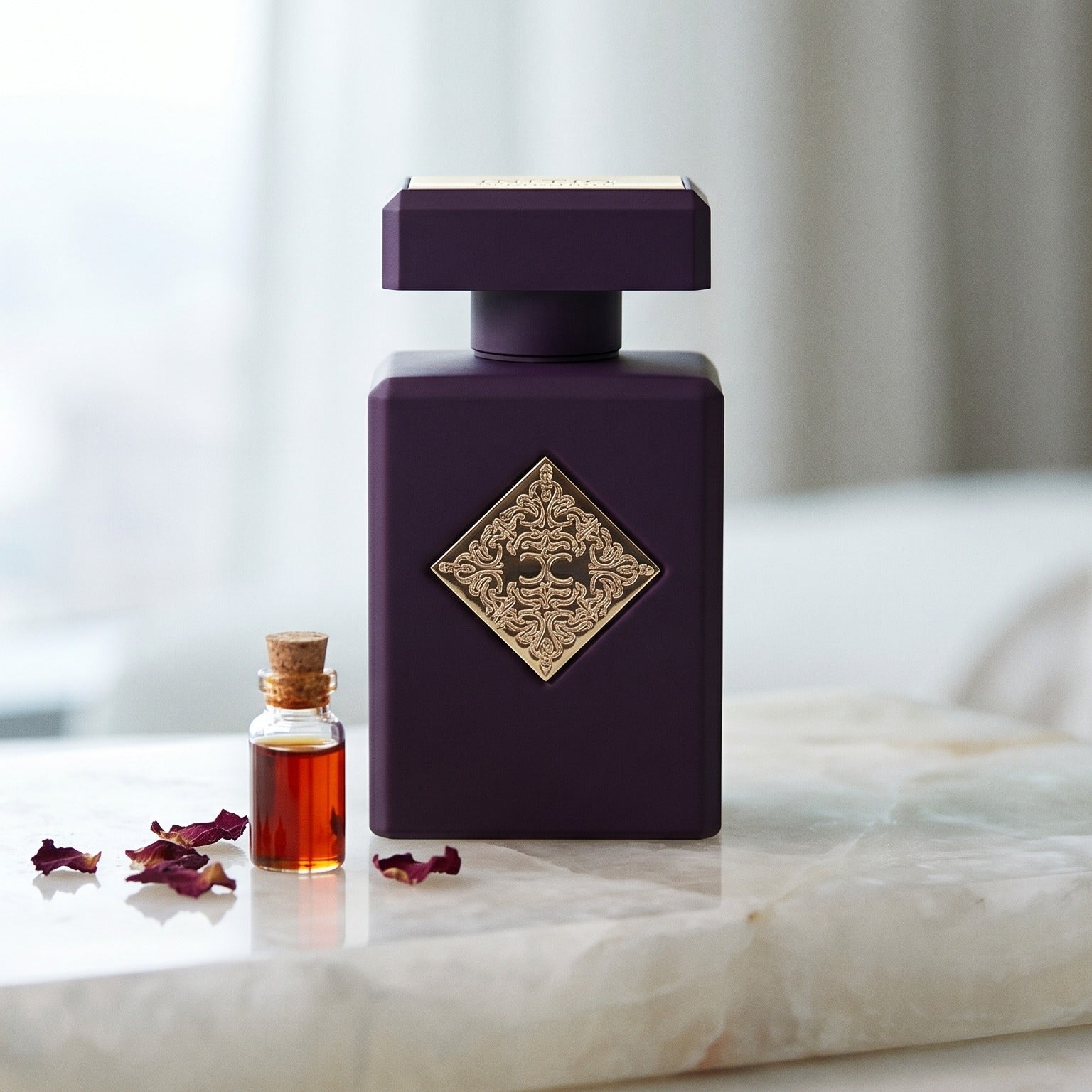 Initio Psychedelic Love EDP on white marble with a porcelain phial of rose essence beside the bottle