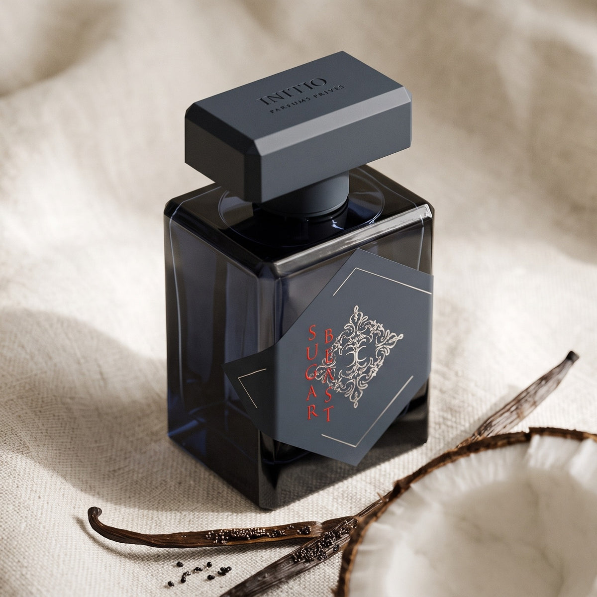 Initio Sugar Blast EDP on cream linen with a halved coconut and vanilla pods
