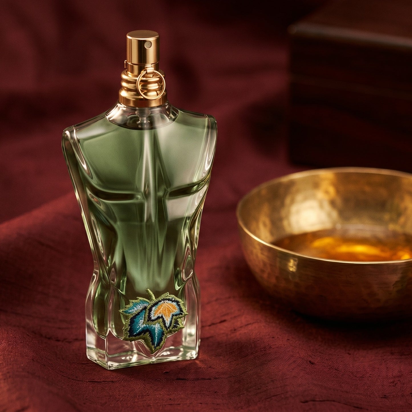 Jean Paul Gaultier Le Beau Paradise Garden on burnt-orange raw silk with a brass vial of frankincense oil