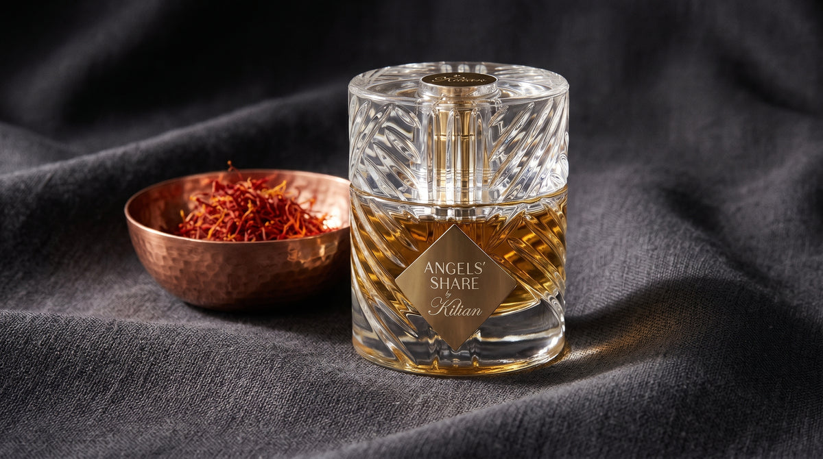 Kilian Angels Share EDP on charcoal linen with a small copper bowl of saffron threads