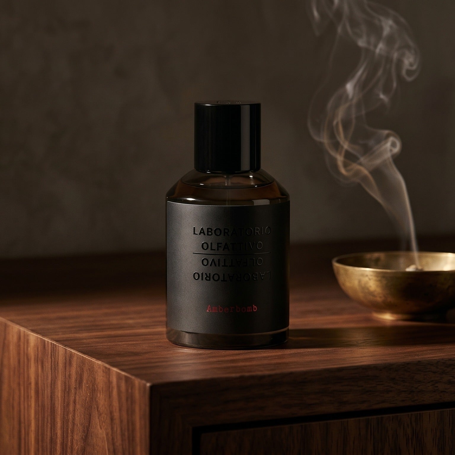 Laboratorio Olfattivo Amberbomb on charcoal slate with a slender oud chip and drifting incense smoke