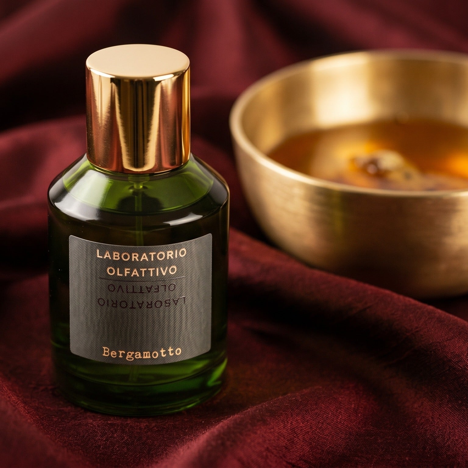 Laboratorio Olfattivo Bergamotto EDP on cinnamon-tone silk with a shallow saucer of warm benzoin resin