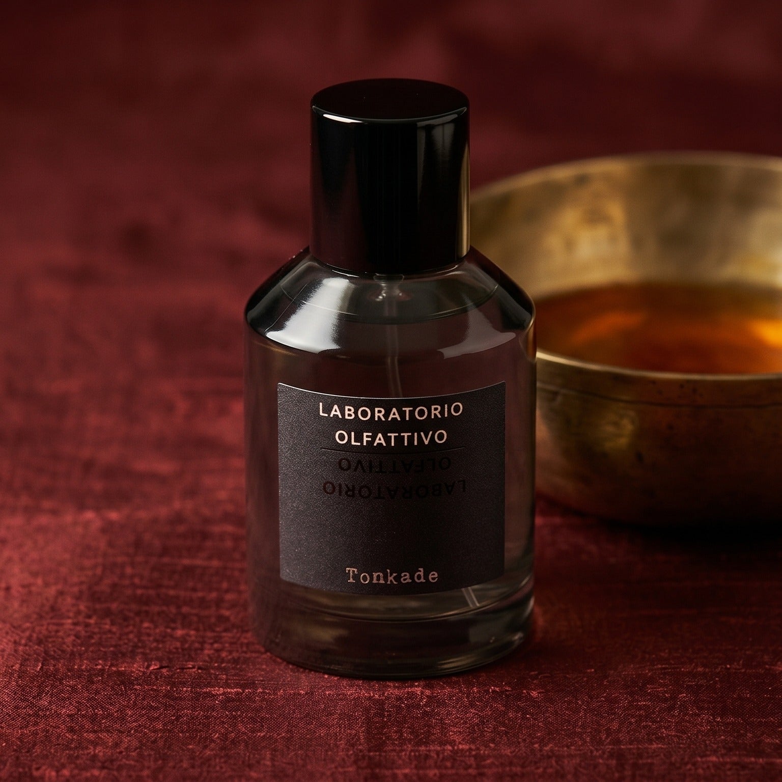 Laboratorio Olfattivo Tonkade on cinnamon-tone silk with a shallow saucer of warm benzoin resin