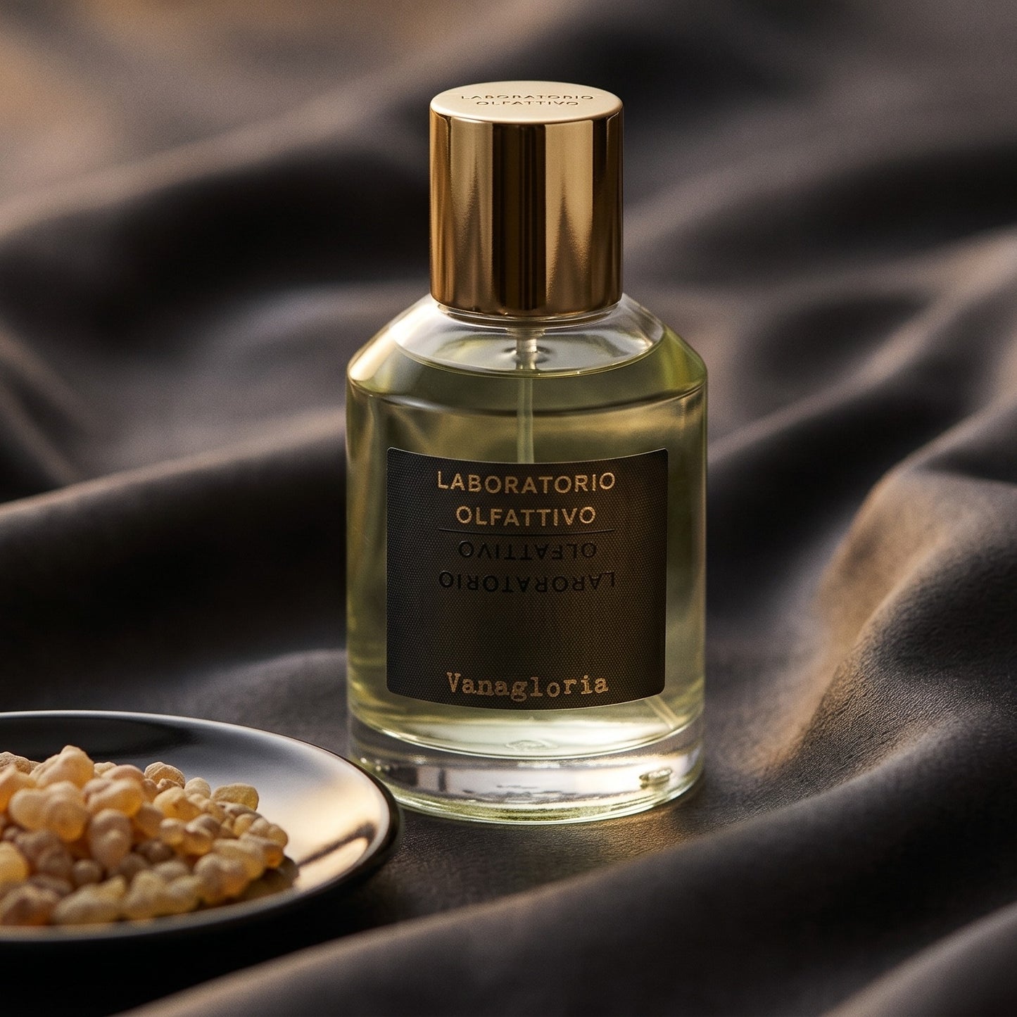 Laboratorio Olfattivo Vanagloria EDP on burnt-orange silk with smoldering agarwood on a stone dish