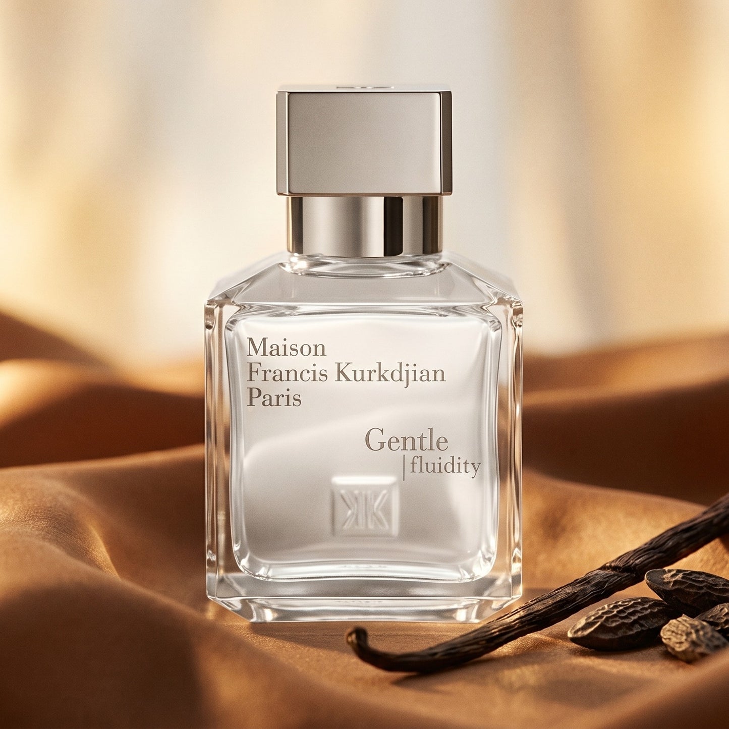 Maison Francis Kurkdjian (MFK) Gentle Fluidity Silver on warm caramel silk with a vanilla pod and tonka bean beside the bo…