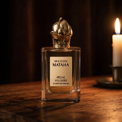 Maison Mataha Peche Velours on aged maple with a slender candlestick and drifting smoke