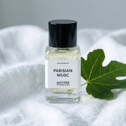 Matiere Premiere Parisian Musc EDP on white linen with a single fresh fig leaf