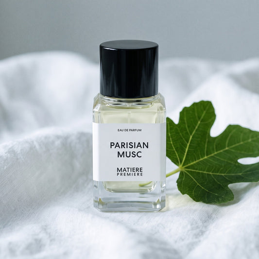 Matiere Premiere Parisian Musc EDP on white linen with a single fresh fig leaf