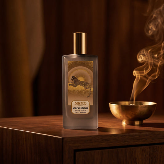 Memo Paris African Leather EDP on dark walnut console with a small brass incense bowl with smoke curling upward