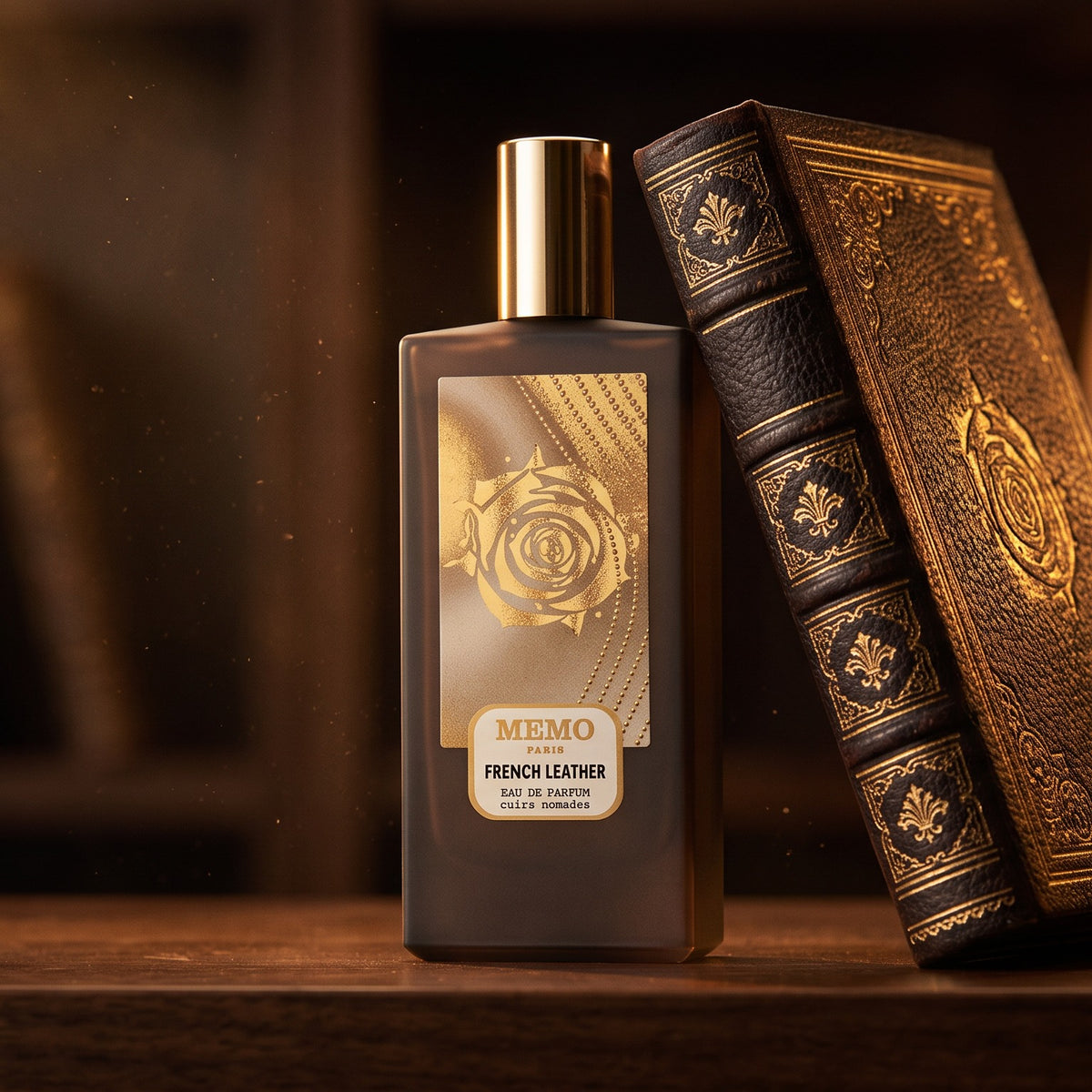 Memo Paris French Leather EDP on dark walnut library shelf with a leather-bound book with gold foil