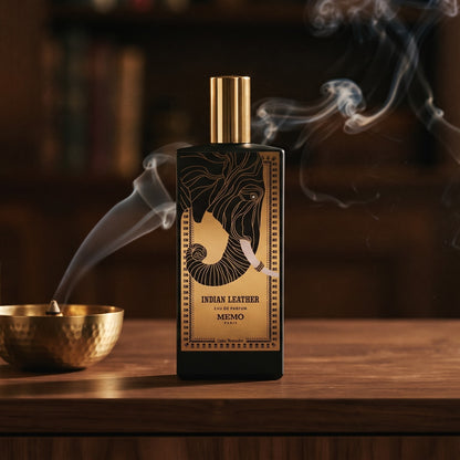 Memo Paris Indian Leather EDP on dark walnut console with a small brass incense bowl with smoke curling upward