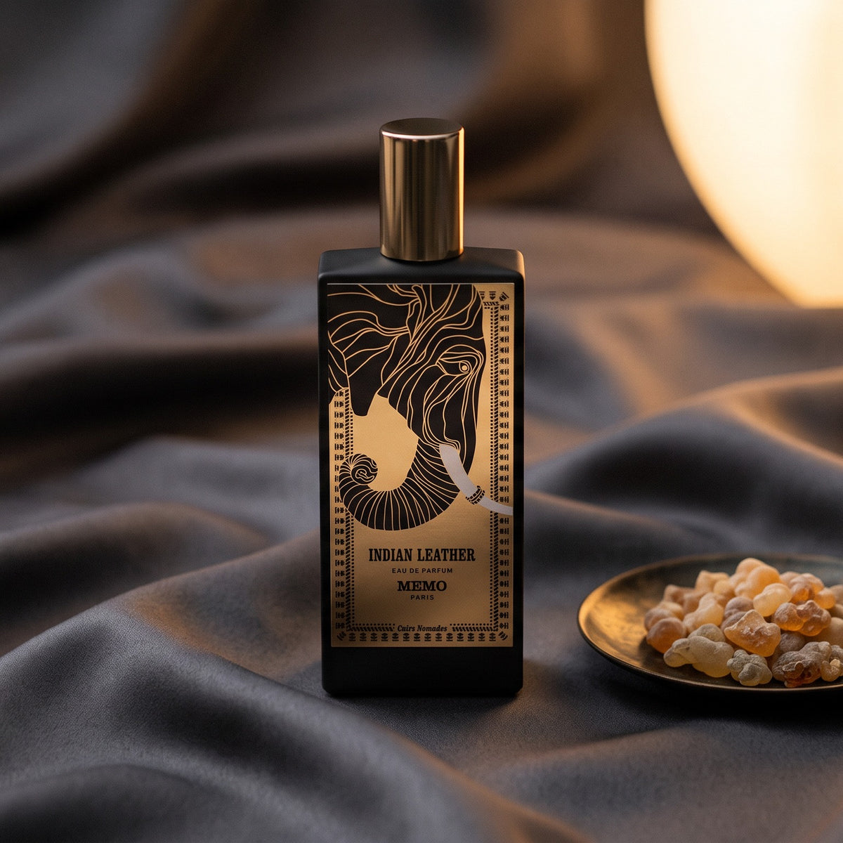 Memo Paris Indian Leather EDP on charcoal silk with frankincense resin granules in a small saucer