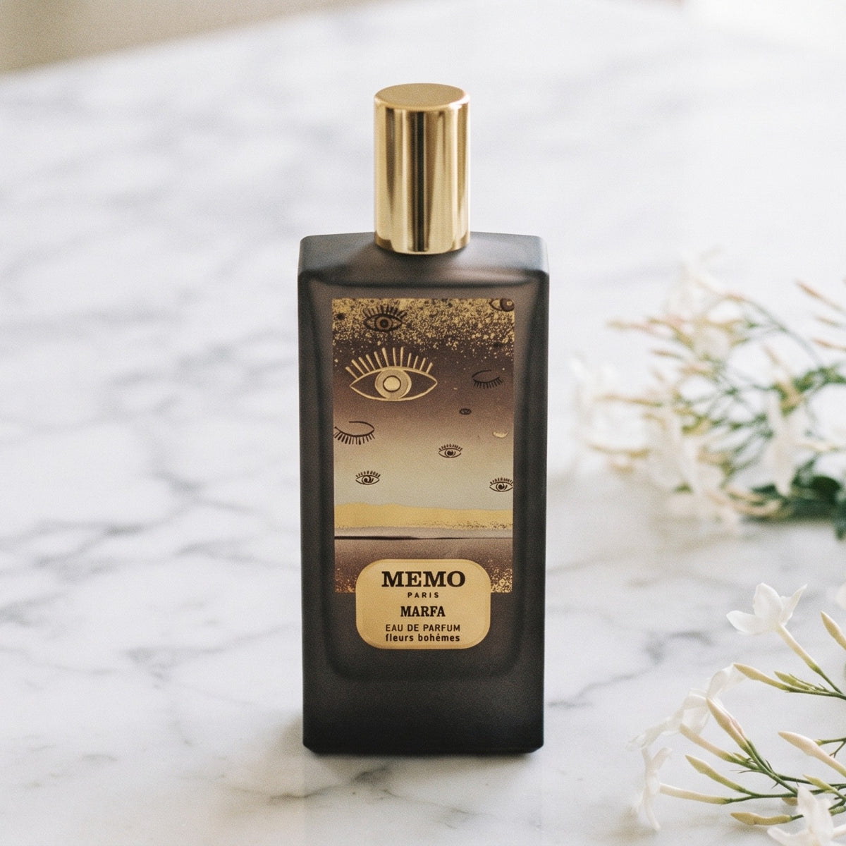 Memo Paris Marfa EDP on white carrara marble with jasmine sprigs placed to frame-right
