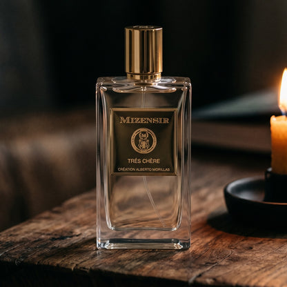 Mizensir Tres Cherre EDP on reclaimed oak surface with a glass hurricane lamp softly glowing