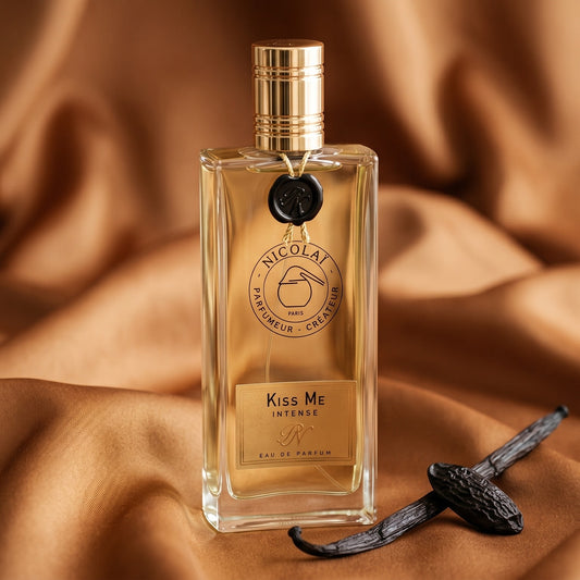 Nicolai Kiss Me Intense EDP on honey-colored satin with a stick of cinnamon and vanilla pods