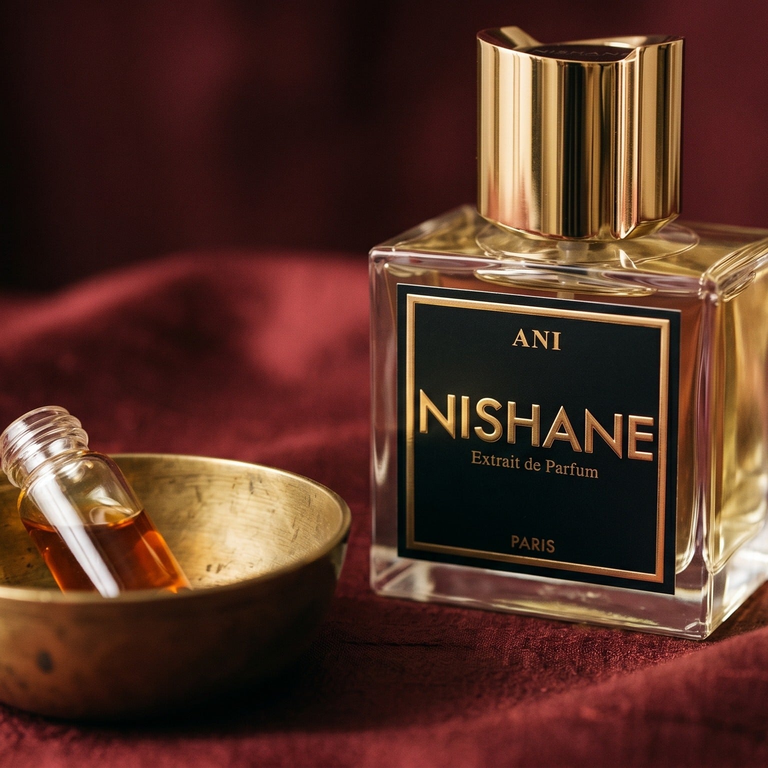 Nishane Ani Extrait de Parfum on cinnamon-tone silk with a shallow saucer of warm benzoin resin