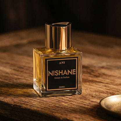 Nishane Ani Extrait de Parfum on aged maple with a slender candlestick and drifting smoke