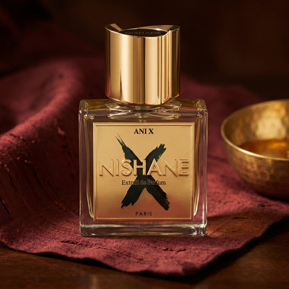 Nishane Ani N(X) Extrait Parfume on burnt-orange raw silk with a brass vial of frankincense oil