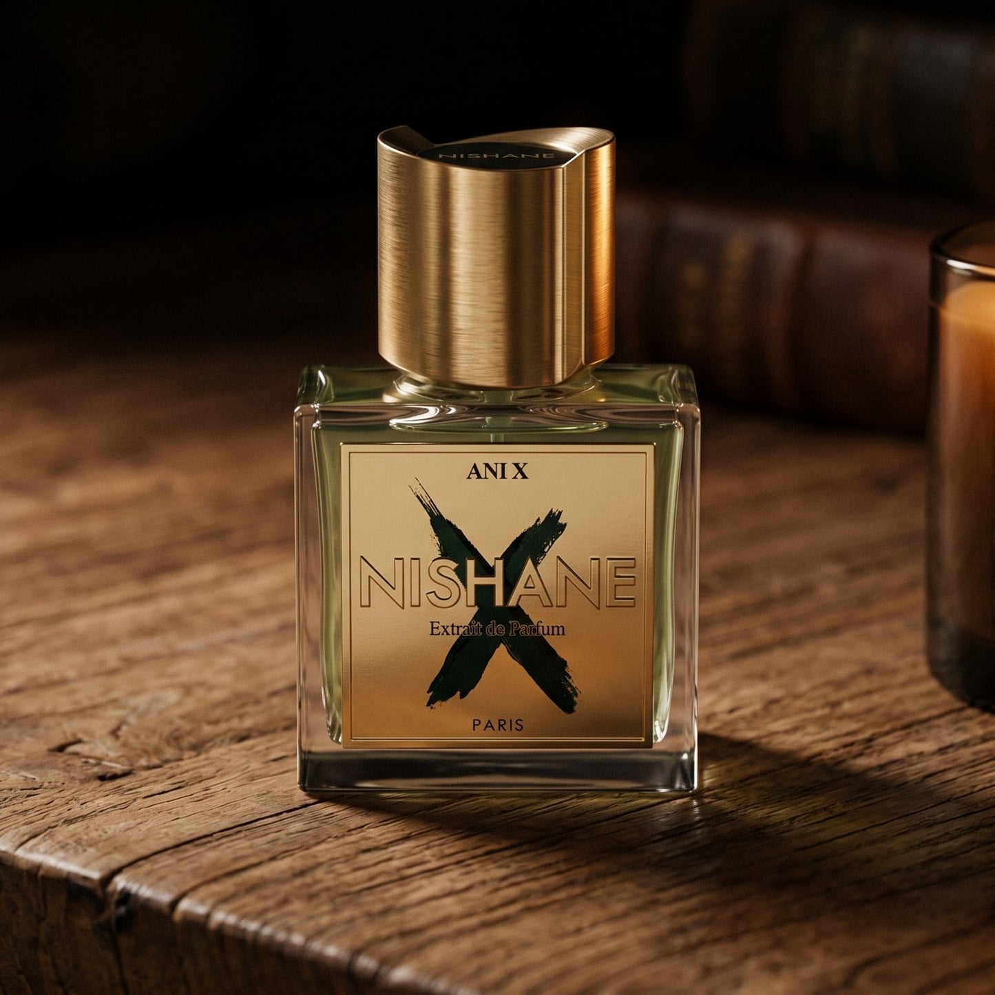Nishane Ani N(X) Extrait Parfume on walnut side table with a pair of lit votives beside the bottle