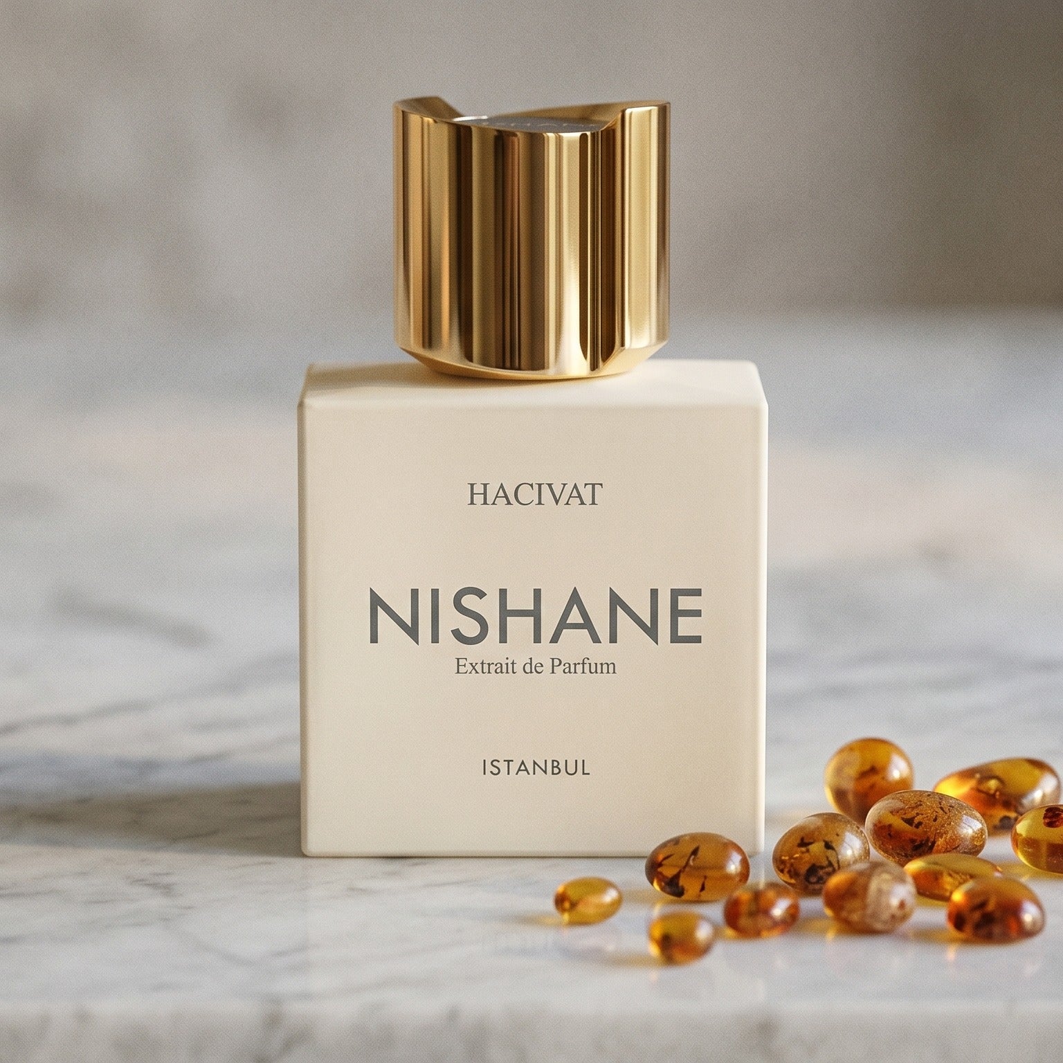 Nishane Hacivat Extrait De Parfum on pale sandstone with golden amber shards catching the light