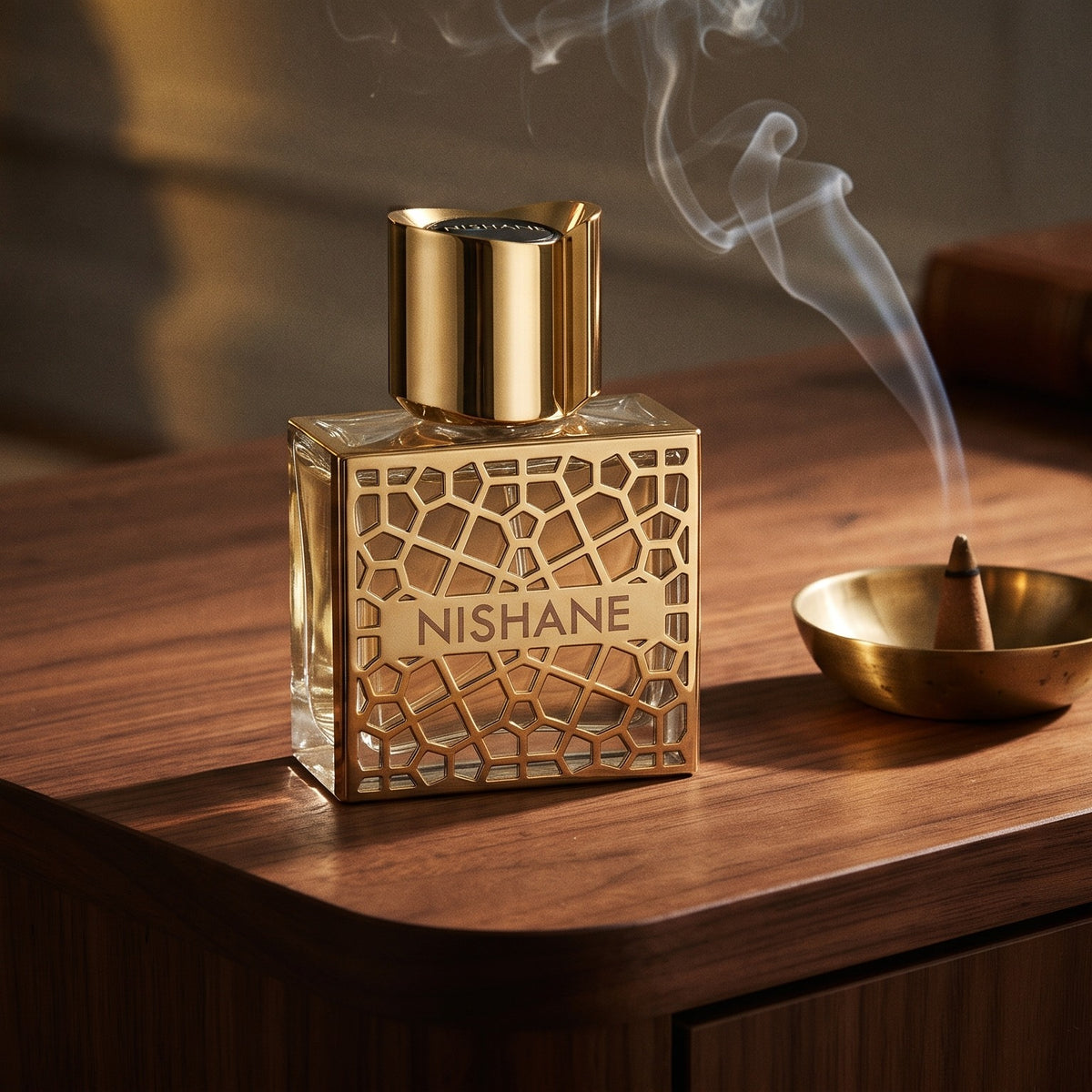 Nishane Hacivat Oud Extrait de Parfum on dark walnut console with a small brass incense bowl with smoke curling upward