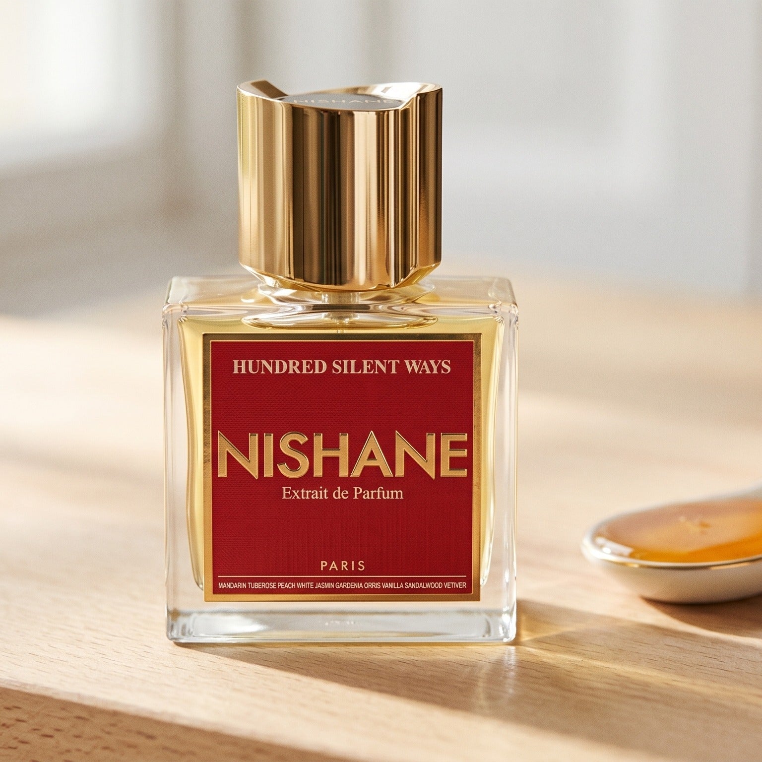 Nishane Hundred Silent Ways EDP on bleached oak with a shallow ramekin of salted caramel