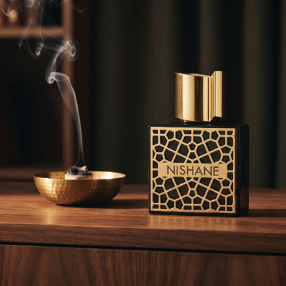 Nishane Mana Extrait de Parfum on dark walnut console with a small brass incense bowl with smoke curling upward