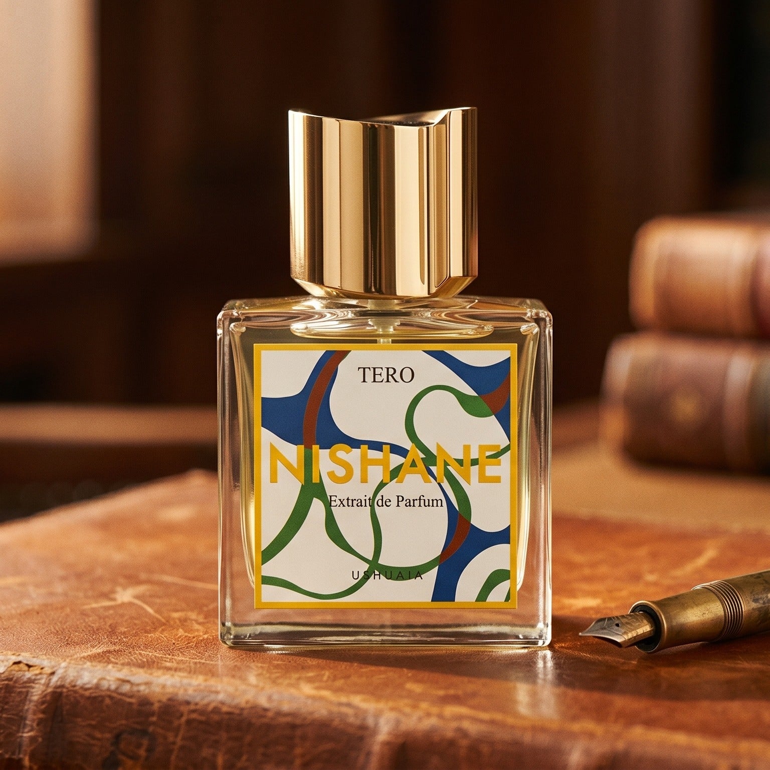 Nishane Tero EDP on aged cognac-leather surface with a brass fountain pen resting beside it