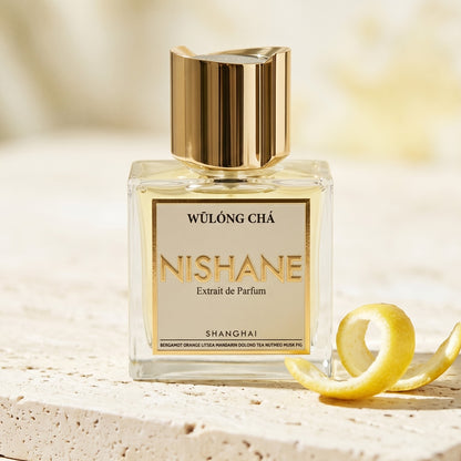 Nishane Wulong Cha EDP on alabaster surface with a yuzu peel shaved in thin curls