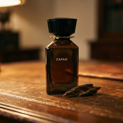 Oman Luxury Zafar EDP on dark tan leather desk with a brass lamp casting a warm pool of light