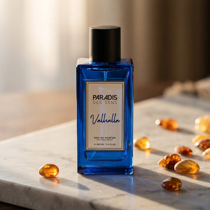 Paradis des Sens Valhalla Eau de Parfume on warm taupe marble with copal beads spilling from a small dish