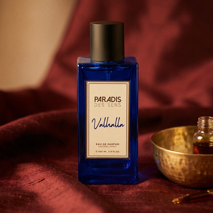 Paradis des Sens Valhalla Eau de Parfume on russet silk with a matte brass bowl holding tonka and amber pieces